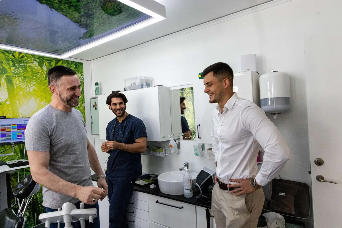 Oscar Cruz of Leadflix, right, in a white shirt, in a treatment room at a dental clinic we've worked with, with 2 of the clinic's team